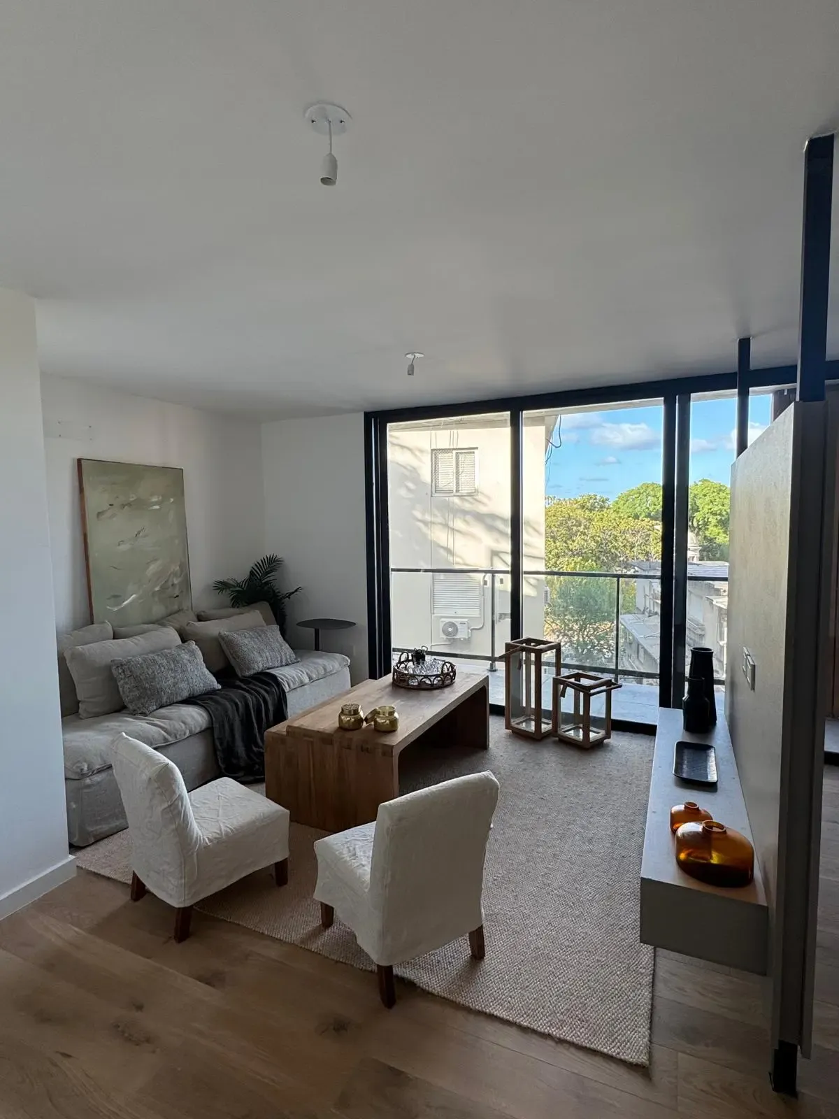 Living con ventanal y vista arbolada